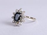 un gros plan d'une bague sertie d'un diamant noir et blanc sur une surface blanche
