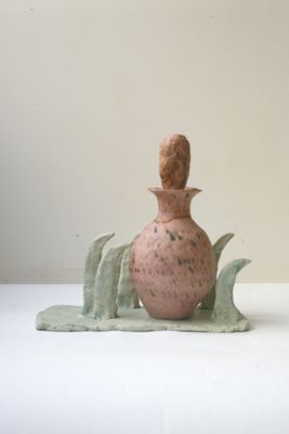 un vase rose orné d'une feuille verte sur un fond blanc