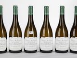 quatre bouteilles de vin sont alignées sur une table