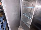 a man standing in front of a refrigerator in a kitchen