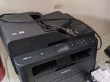 une imprimante posée sur un bureau, à côté d'un téléphone