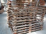 a large pile of wood pallets in a warehouse