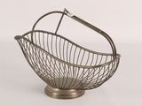 a metal basket with a handle on top of a table
