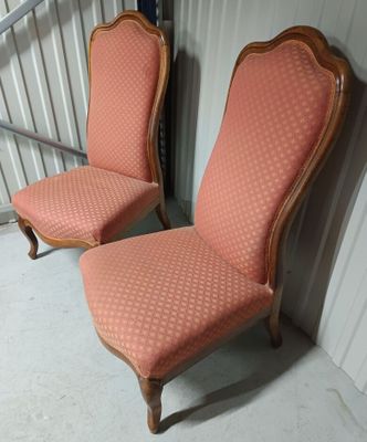 une paire de fauteuils rembourrés roses dans un coin de la pièce