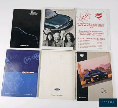 several books are sitting on top of a white table next to a blue car