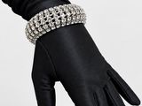 un gros plan d'une personne portant des gants noirs et un bracelet