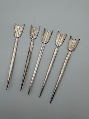 cinq flèches argentées ornées de feuilles, sur un fond blanc