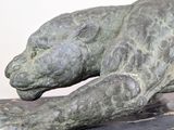 a statue of a lion laying on a marble surface