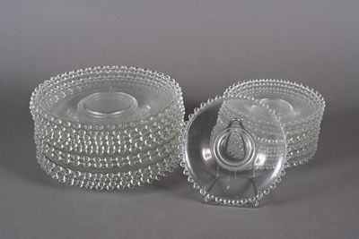 paire de bougeoirs en verre transparent avec des bords ornés de perles sur fond gris