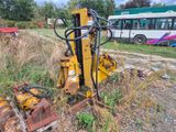 une machine jaune garée à côté d'un bus sur le bord de la route