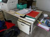 a desk with a printer, file cabinet, and other office supplies on it