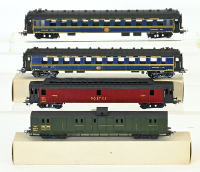 trois trains miniatures sont empilés les uns sur les autres sur une surface blanche
