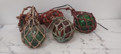 trois boules de Noël en verre vertes et rouges posées sur une table blanche