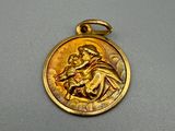 un gros plan d'une médaille d'or sur laquelle figure une image de Jésus