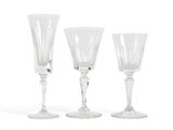 three clear wine glasses sitting next to each other on a white surface