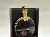 un flacon de parfum posé dans une boîte avec une bague