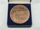 an image of a gold medal in a blue box on a white surface