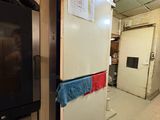 an image of a kitchen with a refrigerator and a tv