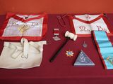 une table recouverte d'une nappe rouge, avec deux tabliers et une paire de ciseaux