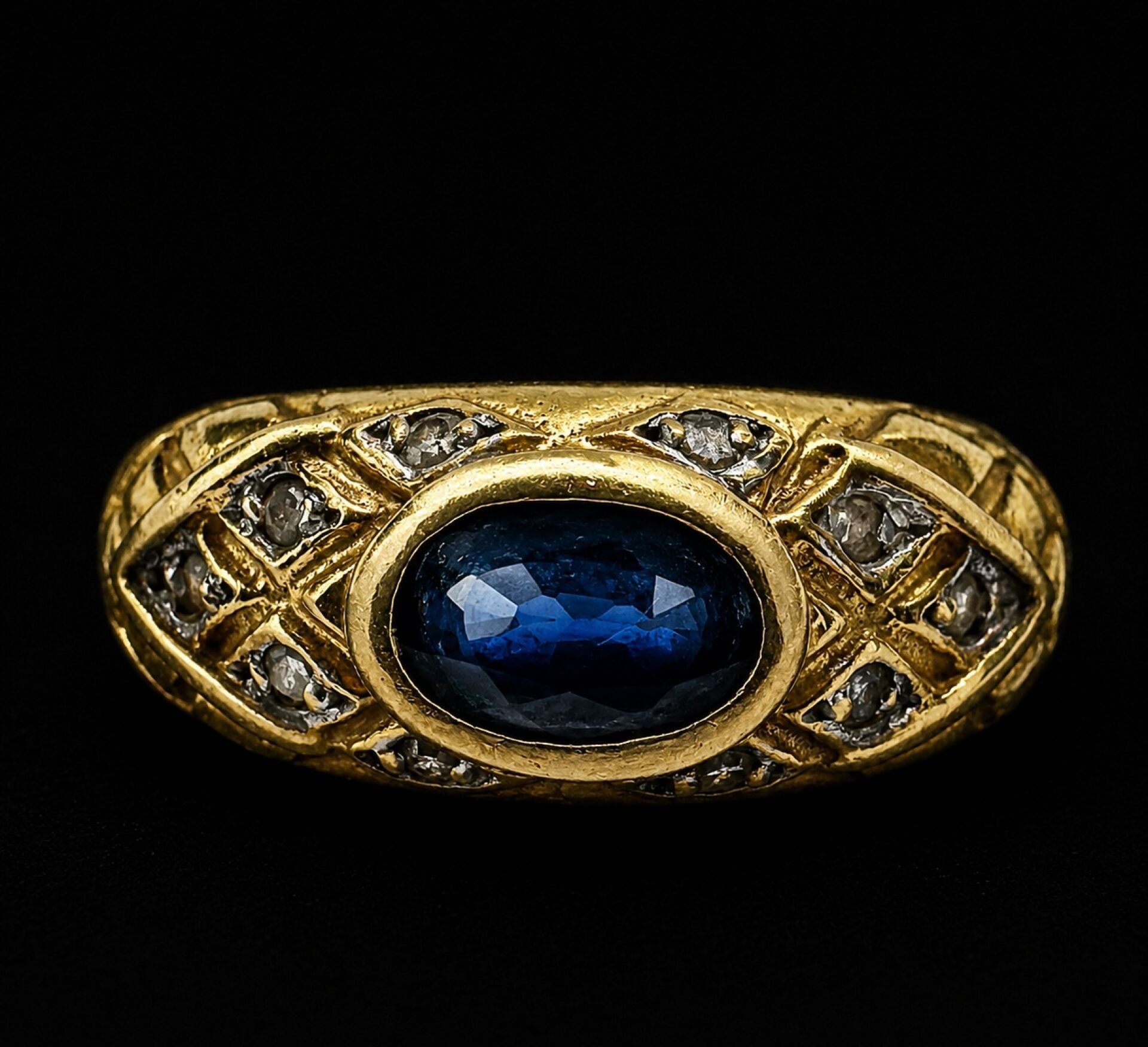 Bague en or jaune 750/1000 à décor ajouré de croisillons, ornée au centre d'un saphir bleu de taille ovale, serti clo...