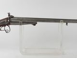 un vieux fusil au canon en bois, posé sur un socle transparent