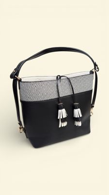 a black and white bag with tassels on top of it