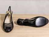 pair of black shoes sitting on top of a wooden table