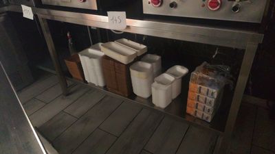 many containers of food sitting on a shelf in the kitchen