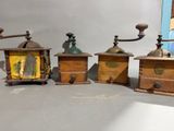 three old fashioned coffee grinders are lined up on a table