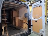 a white van that is inside of a building with its doors open