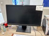 a computer monitor sitting on a desk with a sign on it