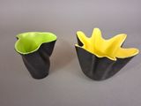 two black and yellow vases sitting on a table