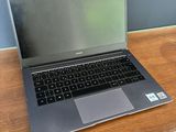 un ordinateur portable posé sur un bureau, à côté d'une tasse de café