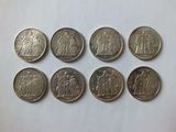 a group of six different coins sitting on top of a white surface