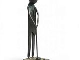 statue d'un homme portant un chapeau et une canne, debout sur un socle carré
