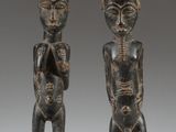 two wooden figures of a man and a woman standing next to each other