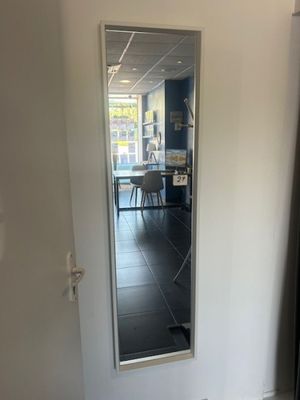 a mirror in the corner of a room with a table in the background