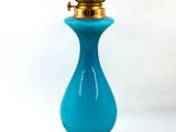 une lampe en verre bleu posée sur une table