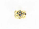 gros plan d'une bague en or avec saphirs et diamants