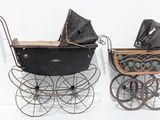 two old fashioned baby strollers sitting next to each other