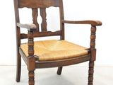 an image of a wooden chair with a woven seat and arm rest