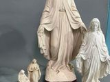 une statue représentant une femme tenant l'enfant Jésus dans ses bras, ainsi que trois autres figurines