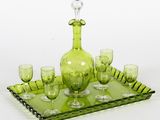 un service composé d'une carafe en verre vert et de verres à vin, présenté sur un plateau