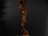 a statue of an angel on a pedestal against a black background
