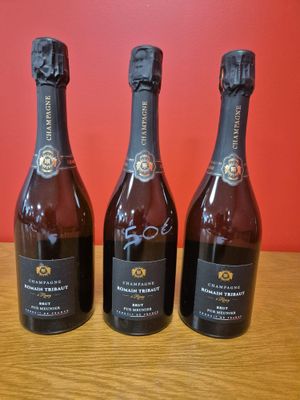 trois bouteilles de vin posées sur une table en bois