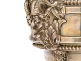 a silver vase that has a lion head on it