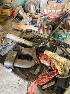 an image of a cluttered garage with tools on the floor