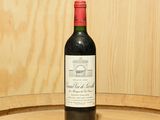 une bouteille de vin posée sur un tonneau