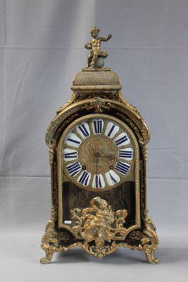a gold clock with blue and white roman numerals on it