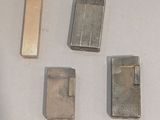 quatre briquets posés les uns à côté des autres sur une table blanche